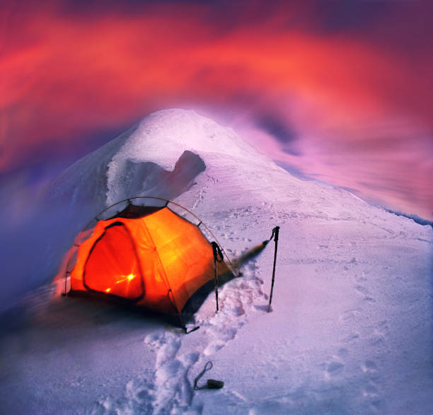 The tent is set on a hillside in winter the most beautiful and the big mountain in the Carpathians-Goverla. Moonrise brought wind and overnight becomes dangerous, Alpine peak in Ukraine is harsh in February
