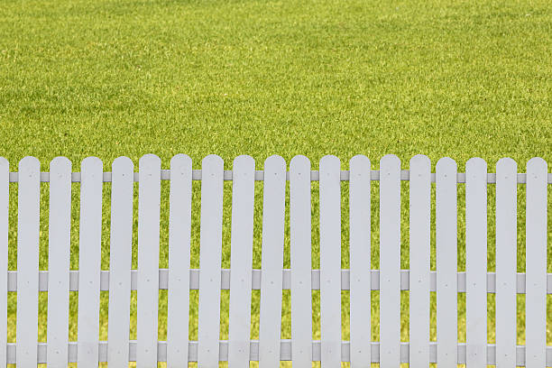 istock White fence on the green lawn. 471936202