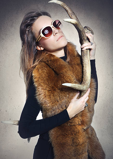 istock Woman in elegant fur coat with deer horn 471936283