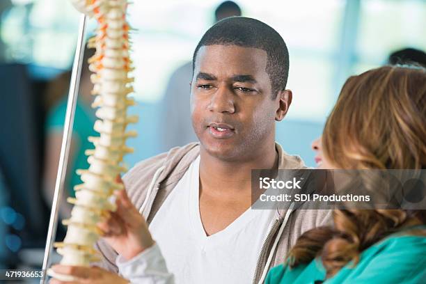 Doctor Or Physical Therapist Explaining Spinal Injury To Patient Stock Photo - Download Image Now