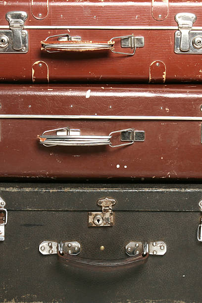 ブラウンとブラックの 3 つの古いスーツケースのパイルクローズアップ - ancient past on the move motion ストックフォトと画像