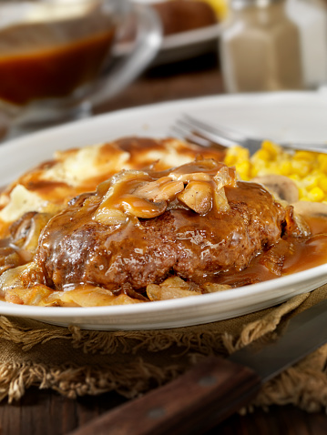 Salisbury Steak Topped with Sauteed Mushrooms and Onions, Mashed Potatoes and Corn on the side and topped with Gravy. - Photographed on Hasselblad H3D2-39mb Camera