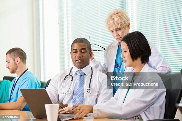 Group Of Doctors Discussing Something During Hospital Board Meeting Stock Photo - Download Image Now