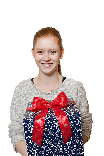 Young red haired Girl presenting a gift stock photo