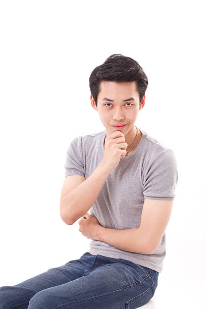 istock confident young man sitting with hand holding chin, white isolat 471943494