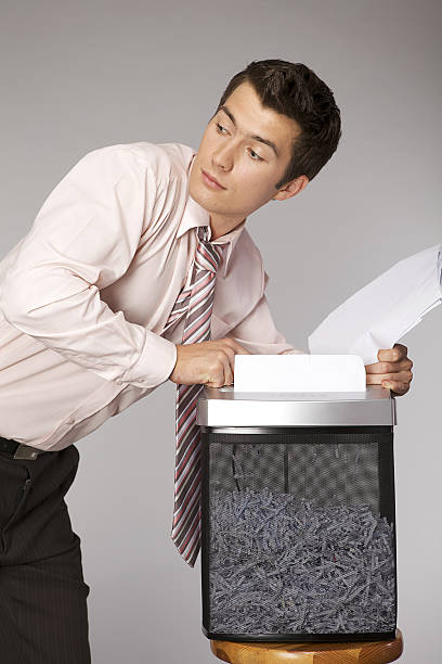 istock Young caucasian businessman shredding documents 471944134