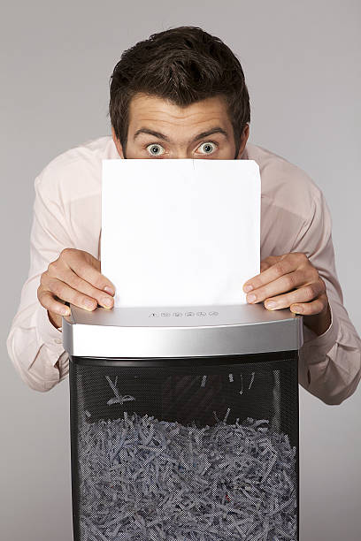 istock Young caucasian businessman shredding documents 471944182