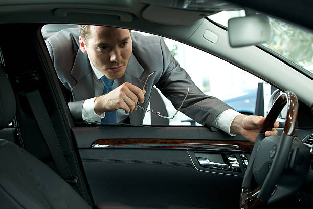 istock Man looking at new car in showroom 471944284