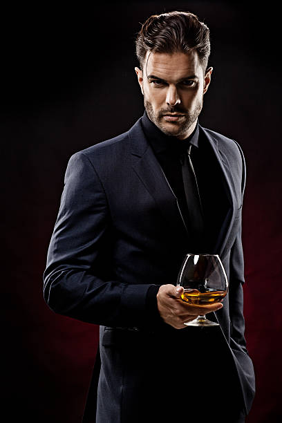 sexy uomo con un bicchiere di whiskey - sex symbol sensuality shirt image foto e immagini stock