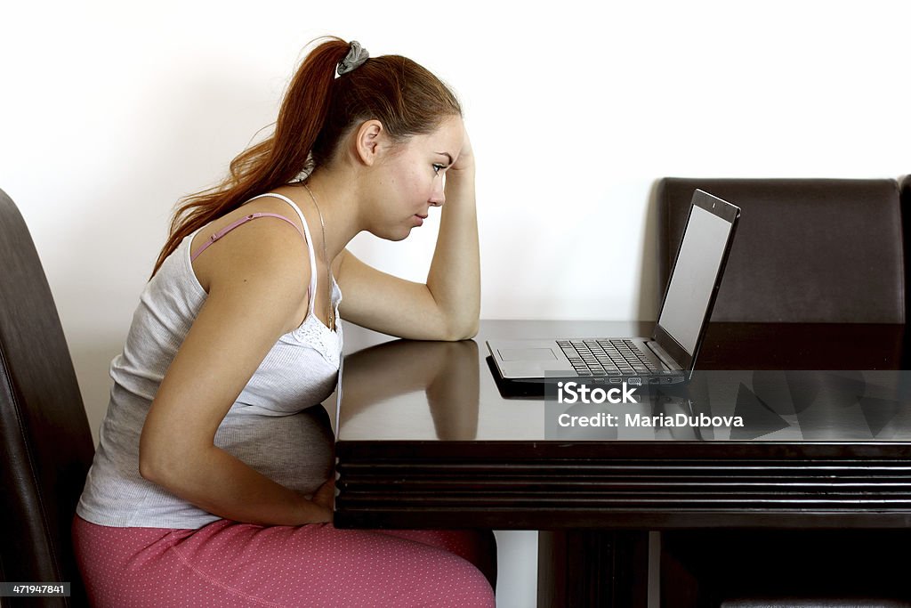 tired young pregnant woman tired young pregnant woman working at home Adult Stock Photo