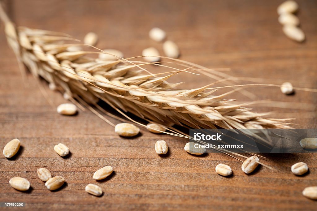 Close up of wheat seed on old wooden table Close up of wheat seed on old wooden table. This file is cleaned and retouched. 2015 Stock Photo