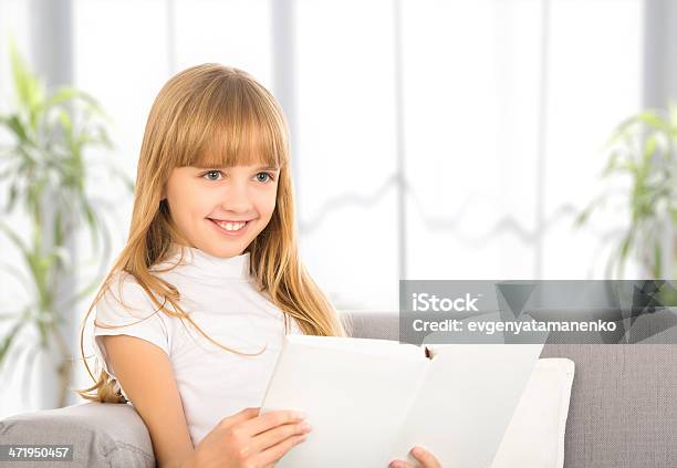 Foto de Criança Feliz Menina Lendo Um Livro Sentado No Sofá e mais fotos de stock de Adolescente