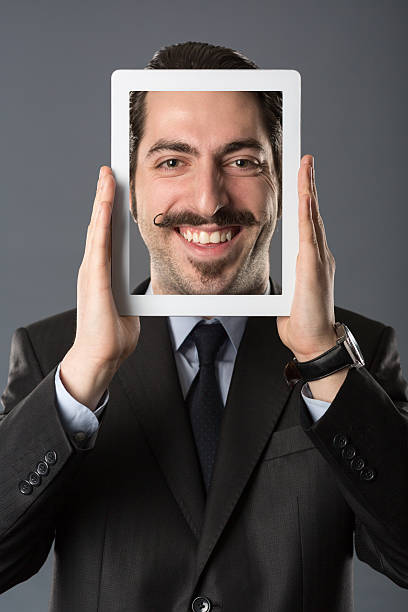 istock Young male holding tablet in front of his head 471950516