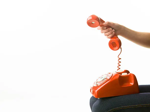 woman answering red phone, on white background. copy space available