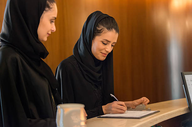Two Middle Eastern Women Signing in at Spa Reception Counter