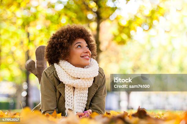 Young Smiling African American Woman Lying On Fall Leaves Stock Photo - Download Image Now