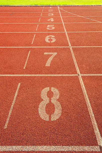 White track number on red rubber racetrack. textured running race tracks in outdoor stadium.