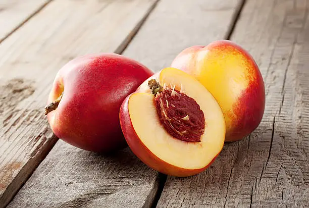 Two and half nectarine on wooden background