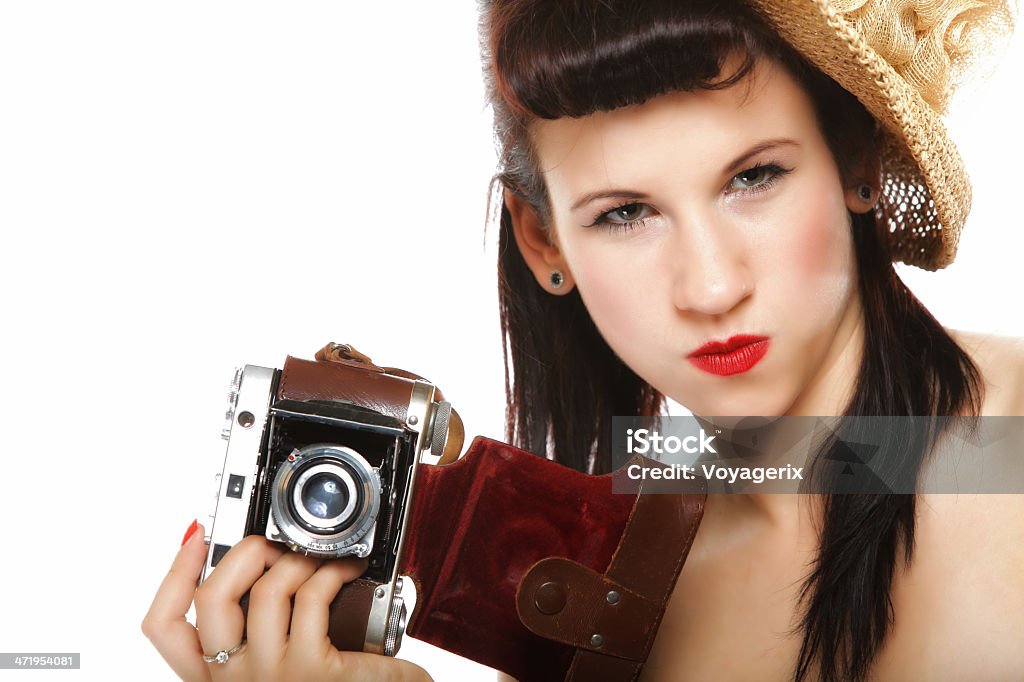 Pretty retro girl in hat with vintage camera pretty retro summer funny girl in hat taking picture using vintage camera white background 1950-1959 Stock Photo