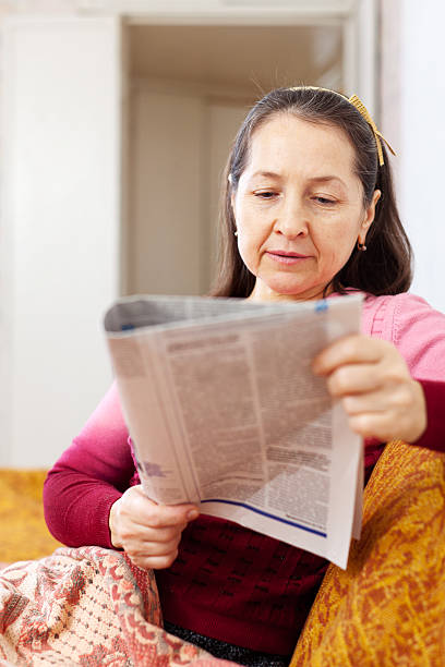 istock pensive woman reading newspaper 471954299