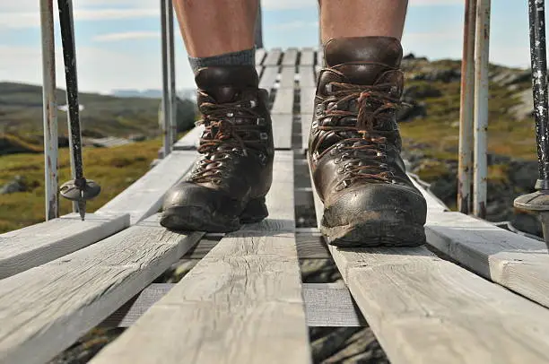 closeup of hiking-shoes crossing a bridge