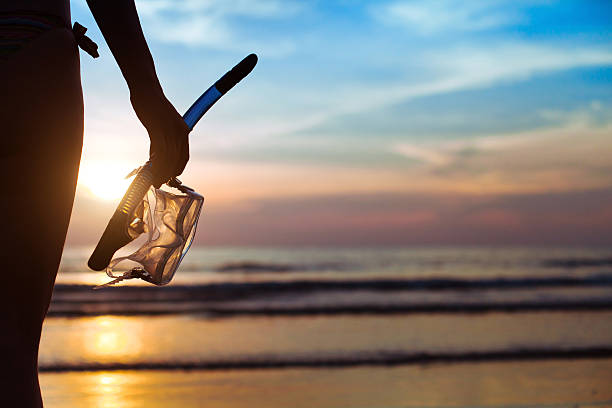diving, silhouette of hand with equipment for snorkeling, on the beach