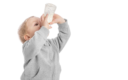 The child drinks a dairy compound from a bottle