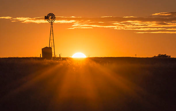 Windmill Sunset The sun sets near a windmill in the Texas Hill Country windmill sunset stock pictures, royalty-free photos & images