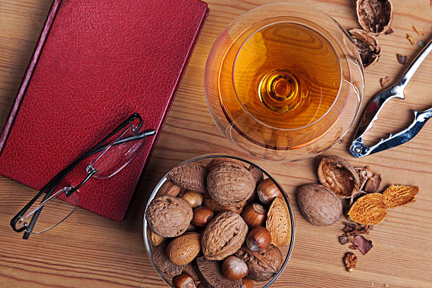 istock Glass of brandy a book and nut selection 471967299