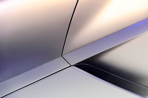 Glittered surface of powerful sport car titanium aerodynamic bodywork with fragment of air intake