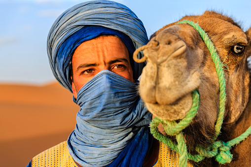 Tuareg with camel on the western part of The Sahara Desert in Morocco. The Sahara Desert is the world's largest hot desert.