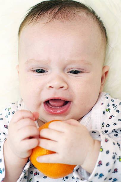 istock baby age of 3 months with tangerine 471973191