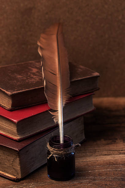 istock old books, scrolls, feather pen and inkwell on wooden table 471973338