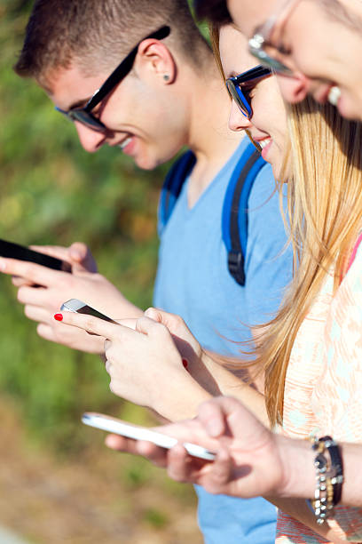 istock Group of students having fun with smartphones after class. 471973484