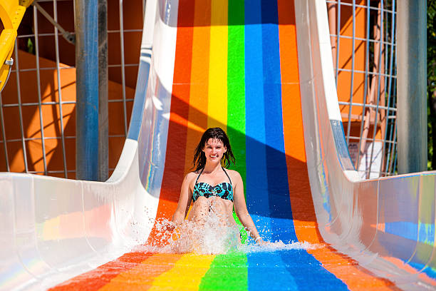 istock Woman in bikini sliding water park 471974020