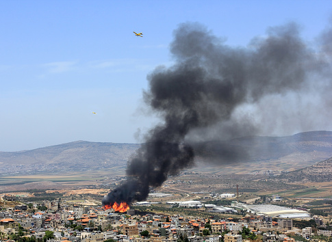 extinguish the fire with the help of aircraft in the palestinian village of Mashhad near Nazareth, Israel