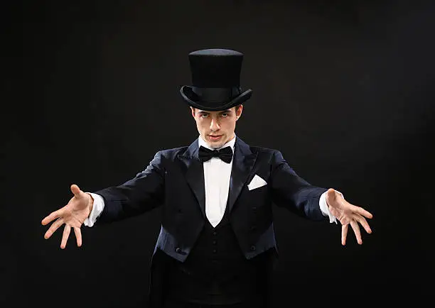 magic, performance, circus, show concept - magician in top hat showing trick