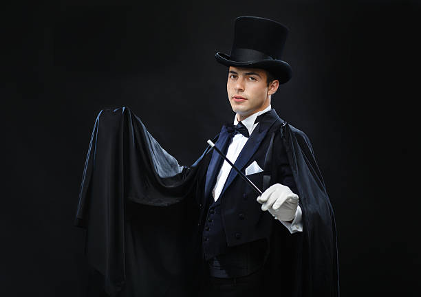istock magician in top hat with magic wand showing trick 471975123