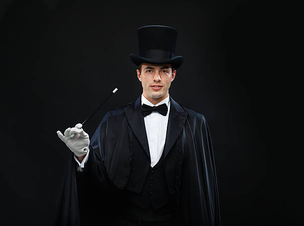 istock magician in top hat with magic wand showing trick 471975199