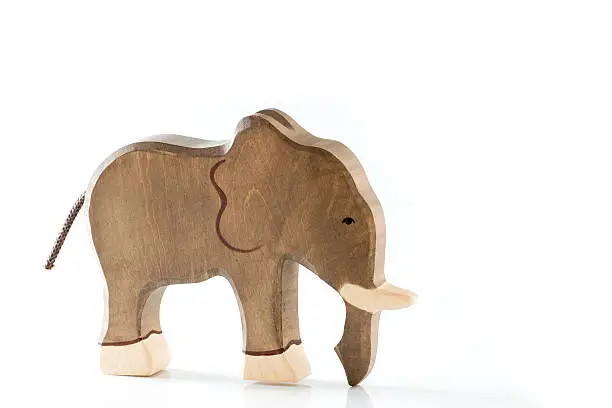 A toy elephant figurine made of wood, isolated on white background.