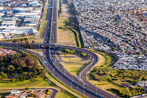 Cape Town M2 highway with Crossroads Township The establishment of Crossroads as a settlement began in the 1970s when workers from a nearby farm were told to move to 'the crossroads'.  segregation stock pictures, royalty-free photos & images