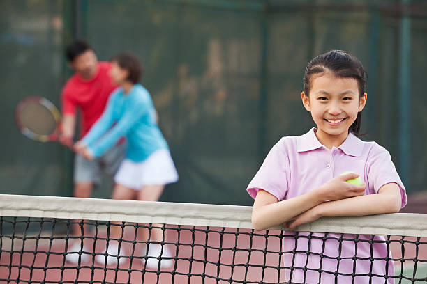 córka stojąc obok siatka do tenisa - tennis men vitality joy zdjęcia i obrazy z banku zdjęć