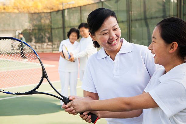 istock Young girl playing tennis with her coach 471984283