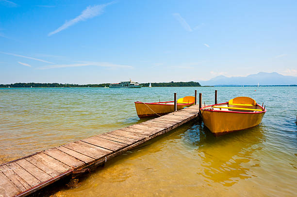 Lake  Chiemsee Yellow Boats Moored on the Lake  Chiemsee bollard pier water lake stock pictures, royalty-free photos & images