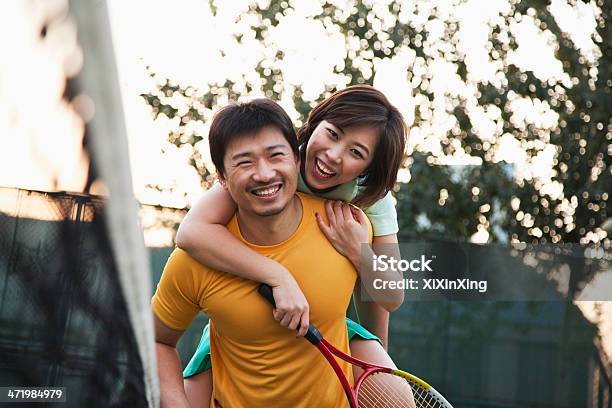 Boyfriend Holding His Girlfriend Next To The Tennis Net Stock Photo - Download Image Now