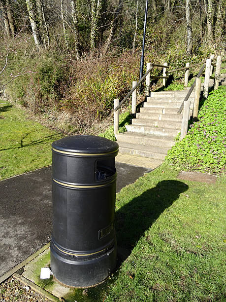 istock Image of round litter bin in park, collecting-rubbish by pathway 471985580