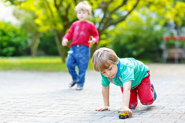 istock Two little kid boys playing with car toys 471986140