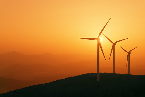 wind turbines silhouette on mountain at sunset