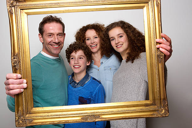 Portrait of a happy family holding picture frame and smiling