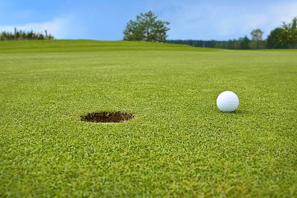 istock Golf, ball lying on the green next to hole 471991623